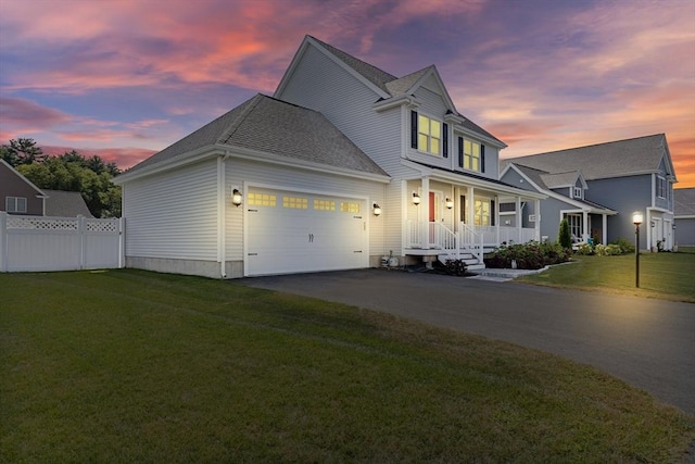 view of front of home with covered porch, driveway, a lawn, and fence