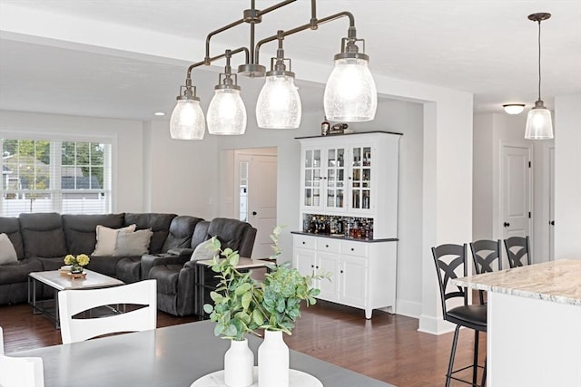 dining space with dark wood-style flooring and baseboards