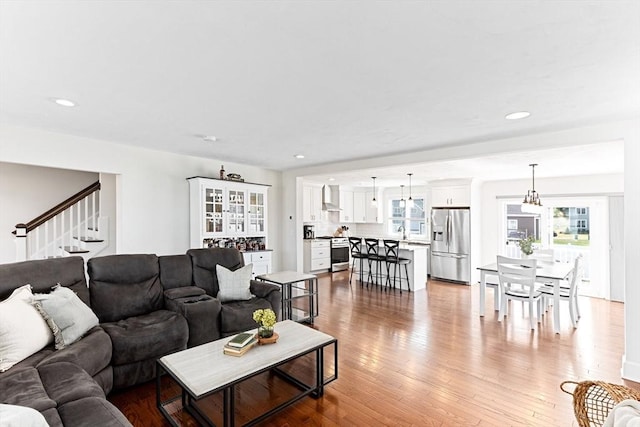 living area featuring stairs, recessed lighting, and light wood-style floors