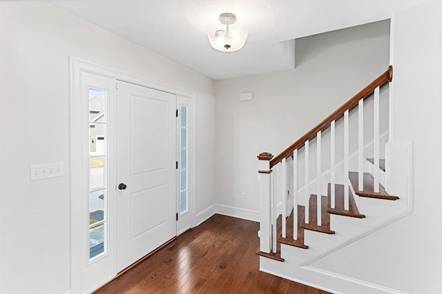 entryway featuring stairs, dark wood-type flooring, and baseboards