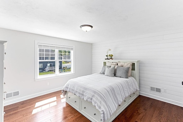 bedroom featuring baseboards, visible vents, and dark wood finished floors