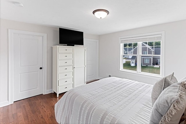 bedroom featuring baseboards and dark wood-style flooring