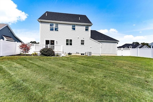 rear view of house featuring a lawn, a fenced backyard, and central air condition unit