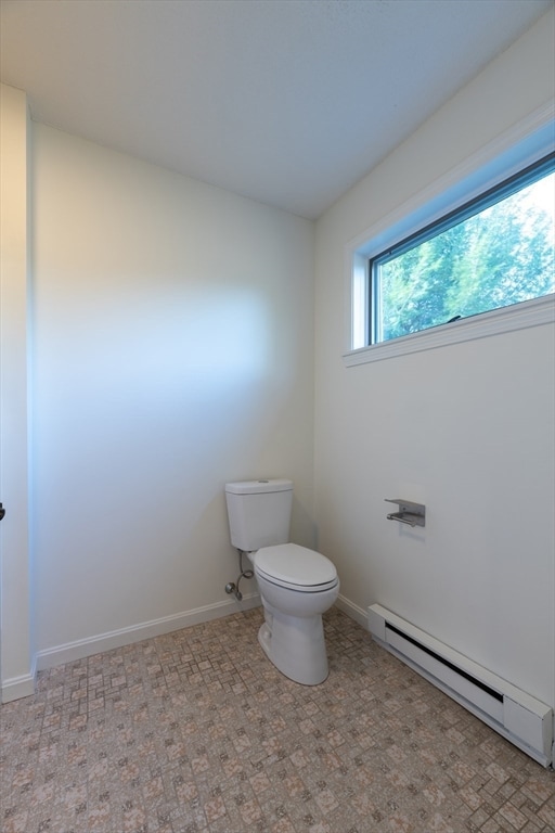 bathroom featuring toilet and a baseboard heating unit