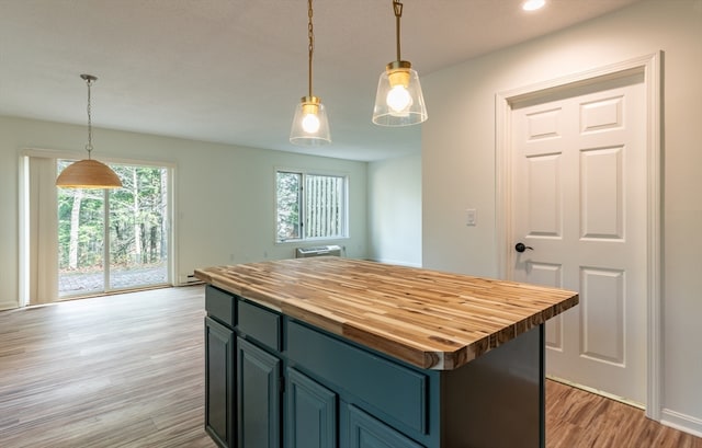 kitchen featuring light wood-type flooring, a kitchen island, and hanging light fixtures