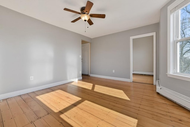 unfurnished room with a baseboard radiator, a wealth of natural light, ceiling fan, and light hardwood / wood-style floors