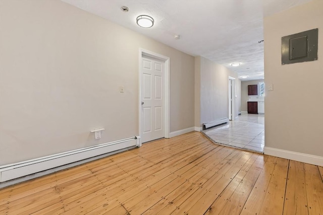 unfurnished room with a baseboard radiator, electric panel, and light hardwood / wood-style floors