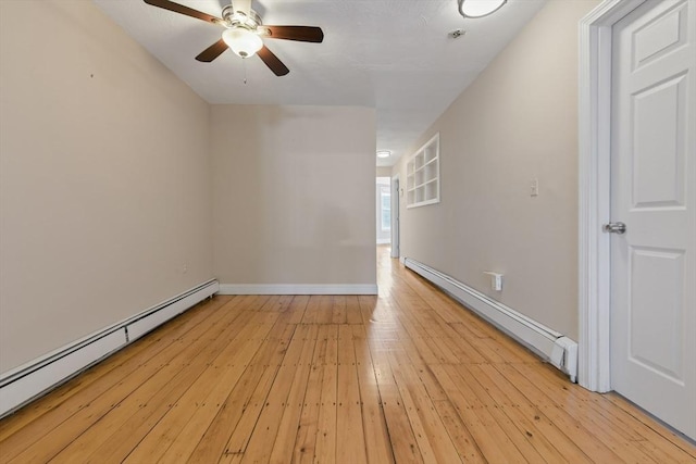 spare room with ceiling fan, a baseboard radiator, and light hardwood / wood-style flooring