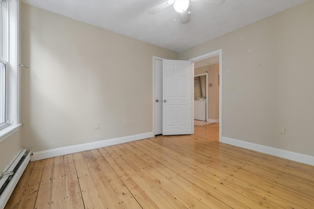 empty room featuring baseboard heating, ceiling fan, and light hardwood / wood-style flooring