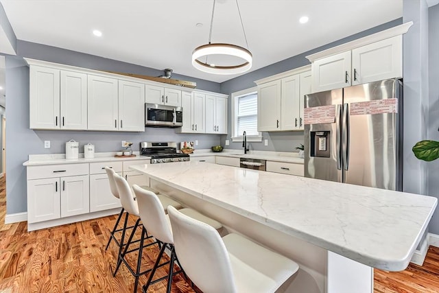 64 Clarkwood Unit 2, Boston, MA 02126 - kitchen featuring stainless steel appliances, white cabinetry, a breakfast bar area, and recessed lighting