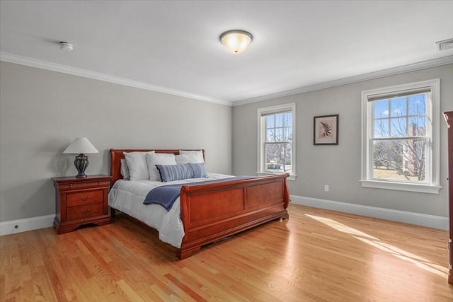 bedroom with light wood-style floors, ornamental molding, and baseboards