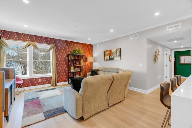 living area featuring baseboards, visible vents, and light wood finished floors