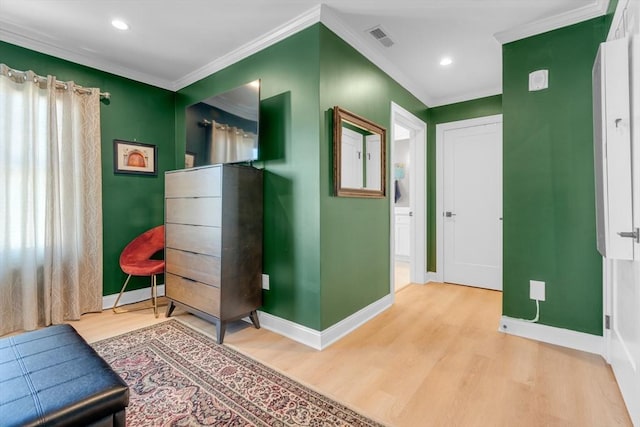 interior space featuring wood finished floors, visible vents, and ornamental molding