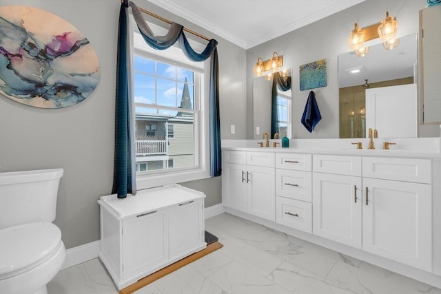 bathroom with toilet, marble finish floor, crown molding, double vanity, and baseboards