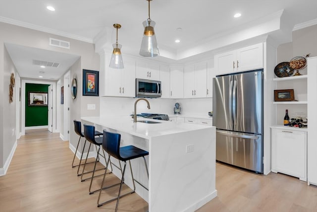 kitchen with a kitchen breakfast bar, visible vents, appliances with stainless steel finishes, and a sink