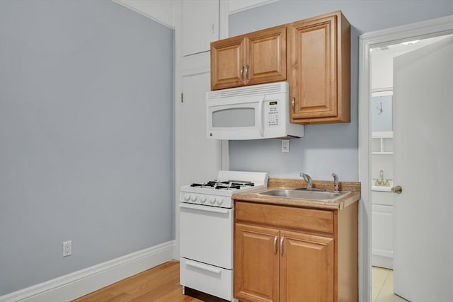 kitchen featuring light hardwood / wood-style floors, white appliances, and sink