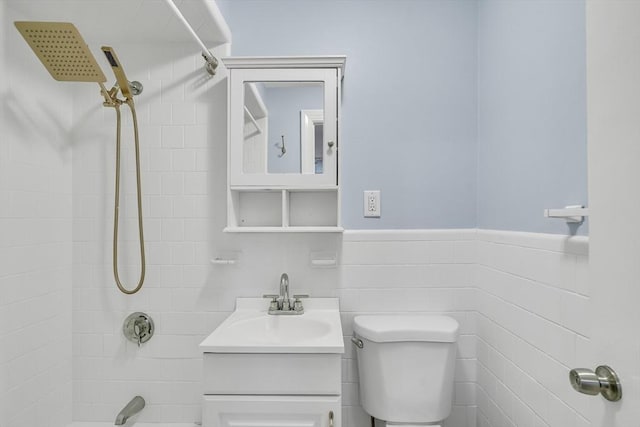 full bathroom with vanity, toilet, tile walls, and tiled shower / bath combo