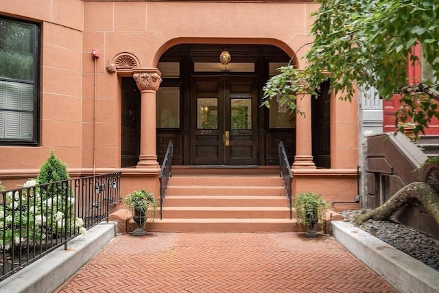 property entrance featuring covered porch and french doors