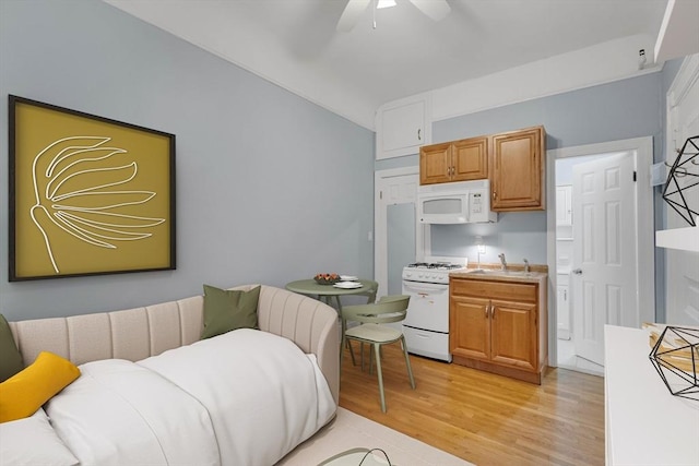 interior space featuring light hardwood / wood-style floors, vaulted ceiling, ceiling fan, and sink