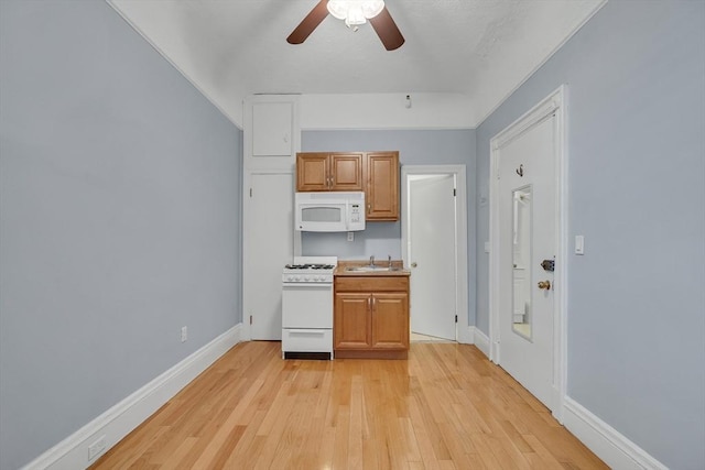 kitchen featuring ceiling fan, sink, light hardwood / wood-style floors, white appliances, and light brown cabinetry