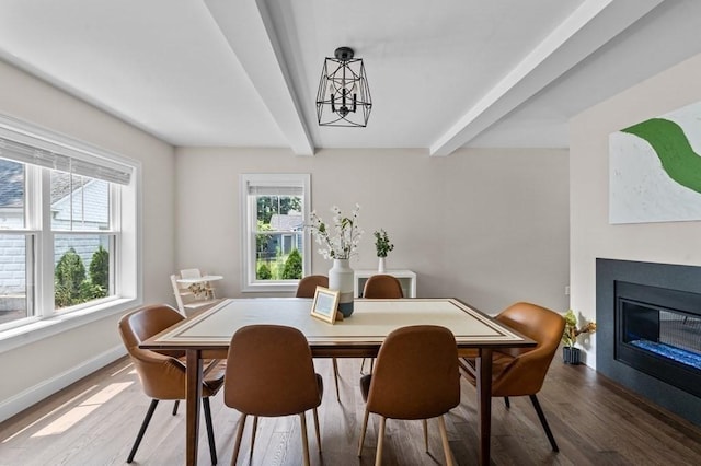 dining room with beamed ceiling, hardwood / wood-style flooring, and a notable chandelier