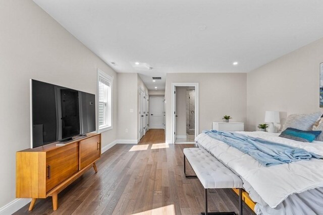 bedroom with hardwood / wood-style floors and ensuite bath