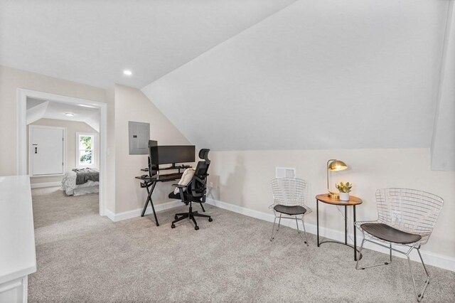 carpeted office space with electric panel and vaulted ceiling