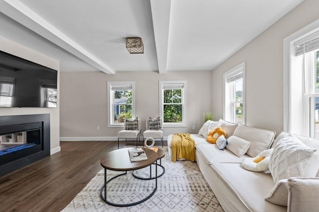 living room featuring beamed ceiling and dark wood-type flooring