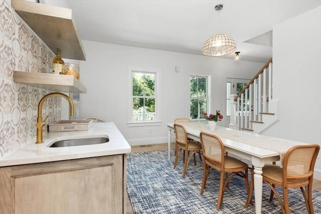 dining area with stairway, baseboards, and wood finished floors