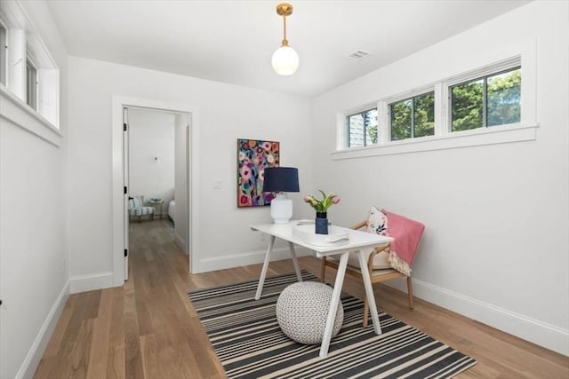 office area with visible vents, light wood-style flooring, and baseboards