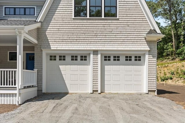 garage with aphalt driveway and a porch