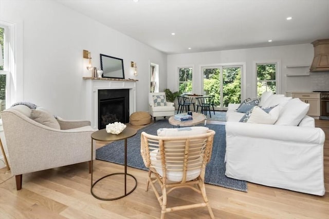 living room featuring light wood-type flooring, a fireplace, and recessed lighting