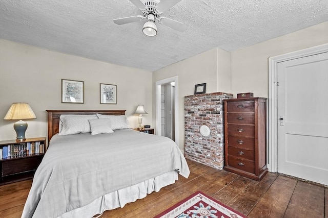 bedroom featuring ceiling fan, dark hardwood / wood-style floors, and a textured ceiling