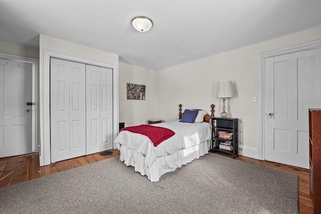 bedroom with dark wood-type flooring and a closet