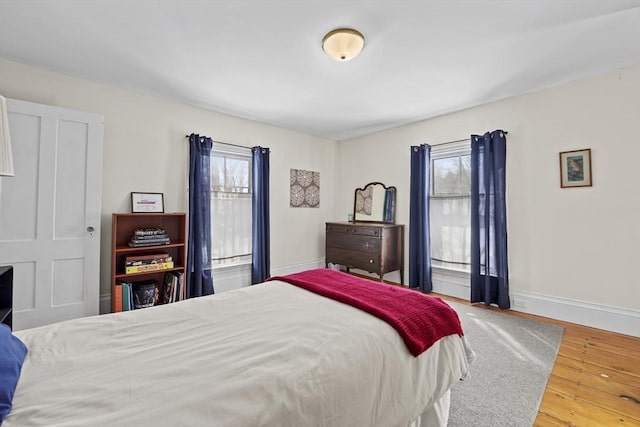 bedroom with multiple windows and hardwood / wood-style flooring