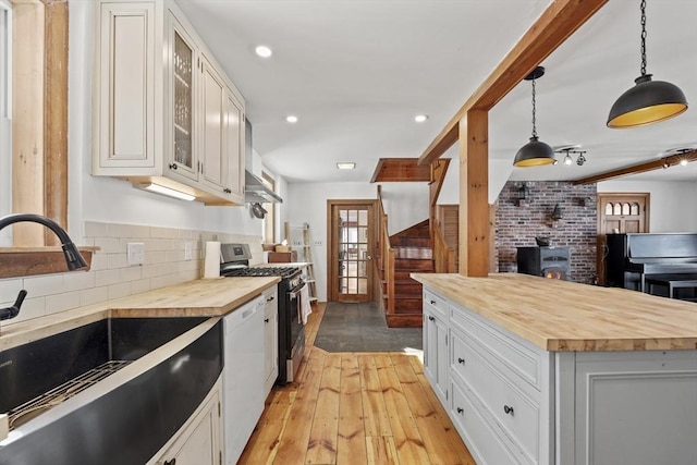 kitchen with dishwasher, white cabinetry, hanging light fixtures, a center island, and gas stove