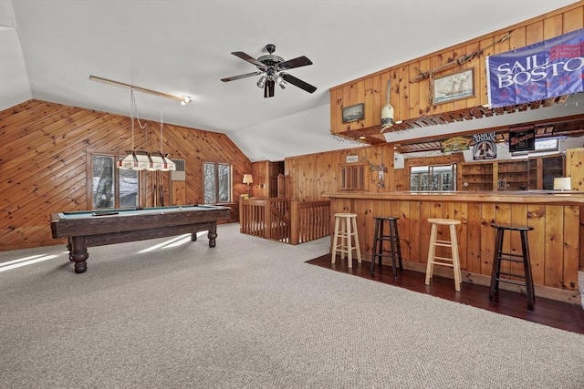 game room with lofted ceiling, wooden walls, dark colored carpet, pool table, and indoor bar