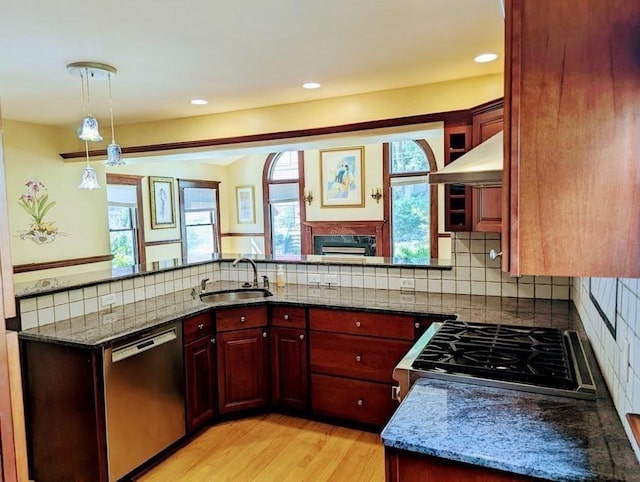 43 Brunswick Rd, Arlington, MA 02474 - kitchen with reddish brown cabinets, dark stone counters, appliances with stainless steel finishes, and under cabinet range hood