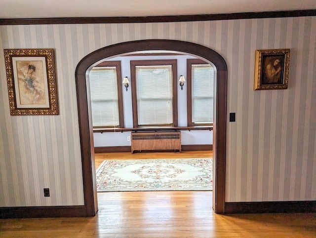 43 Brunswick Rd, Arlington, MA 02474 - foyer entrance featuring arched walkways, baseboards, radiator heating unit, and wood finished floors