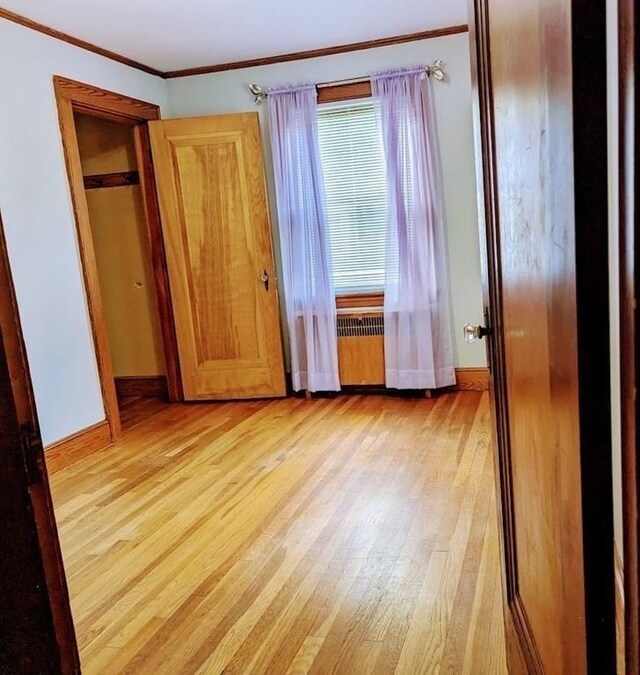 43 Brunswick Rd, Arlington, MA 02474 - unfurnished bedroom featuring light wood-type flooring, radiator, crown molding, and baseboards