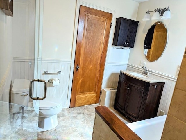 43 Brunswick Rd, Arlington, MA 02474 - bathroom with vanity, wainscoting, toilet, tile patterned floors, and a stall shower