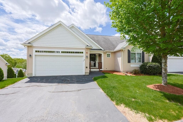 ranch-style home with asphalt driveway, a front yard, and an attached garage