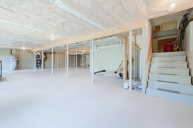 unfinished basement featuring gas water heater and stairs