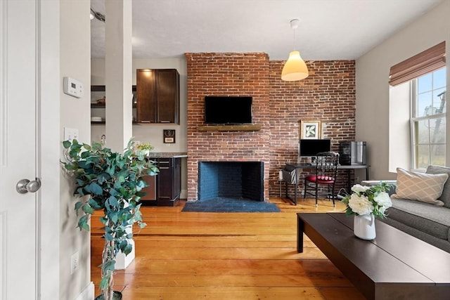 living room featuring light wood-style flooring and a fireplace