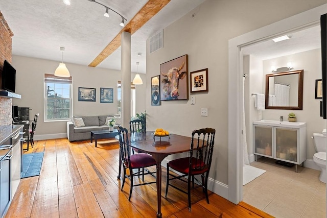 dining space with visible vents, baseboards, and light wood-style floors