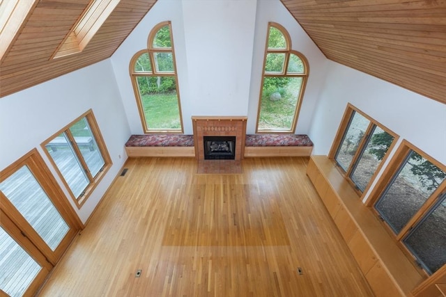 9 Beetlebung Grove Way, Chilmark, MA 02535 - unfurnished living room with wood-type flooring, high vaulted ceiling, healthy amount of natural light, and a tile fireplace