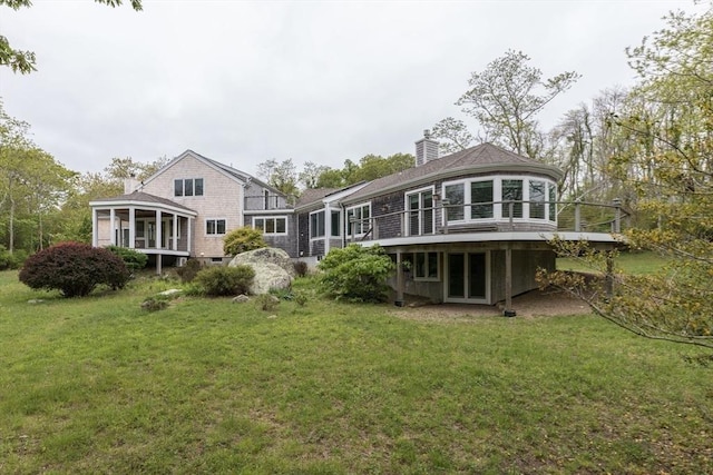 9 Beetlebung Grove Way, Chilmark, MA 02535 - back of property with a sunroom, a chimney, a deck, and a lawn