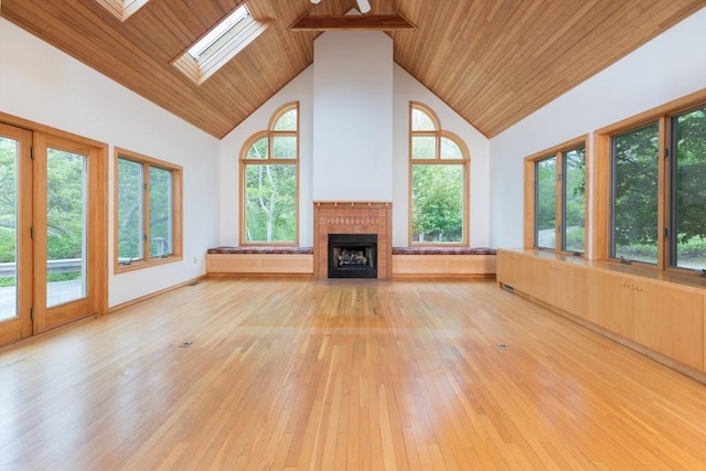 9 Beetlebung Grove Way, Chilmark, MA 02535 - unfurnished living room with high vaulted ceiling, light wood-type flooring, a tiled fireplace, wood ceiling, and a skylight