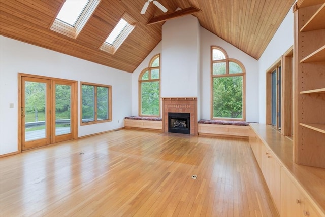 9 Beetlebung Grove Way, Chilmark, MA 02535 - unfurnished living room with high vaulted ceiling, wooden ceiling, a fireplace with flush hearth, light wood-style floors, and a skylight