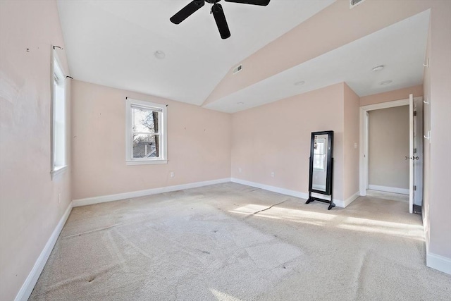 spare room featuring ceiling fan, lofted ceiling, and light carpet